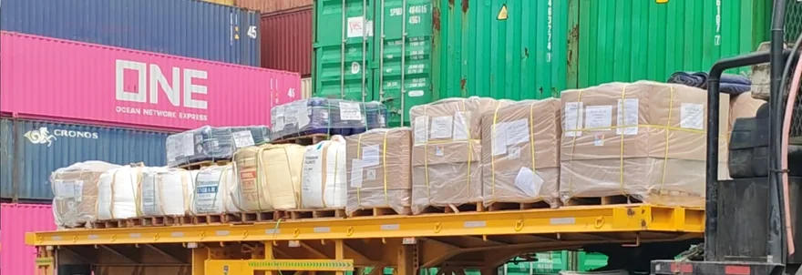 Trailer flatbed di depan tumpukan container, Pelabuhan Belawan