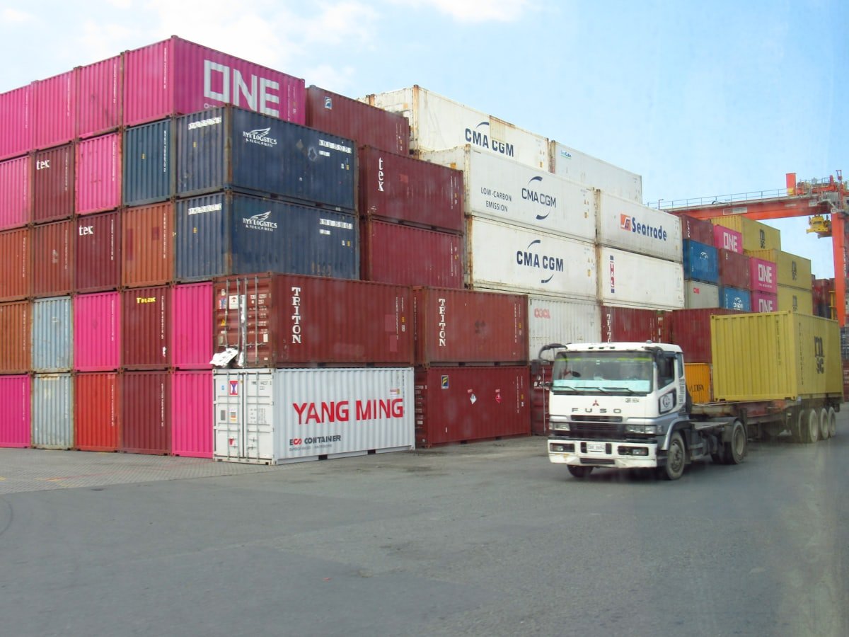 Tumpukan container dan truk di area industri