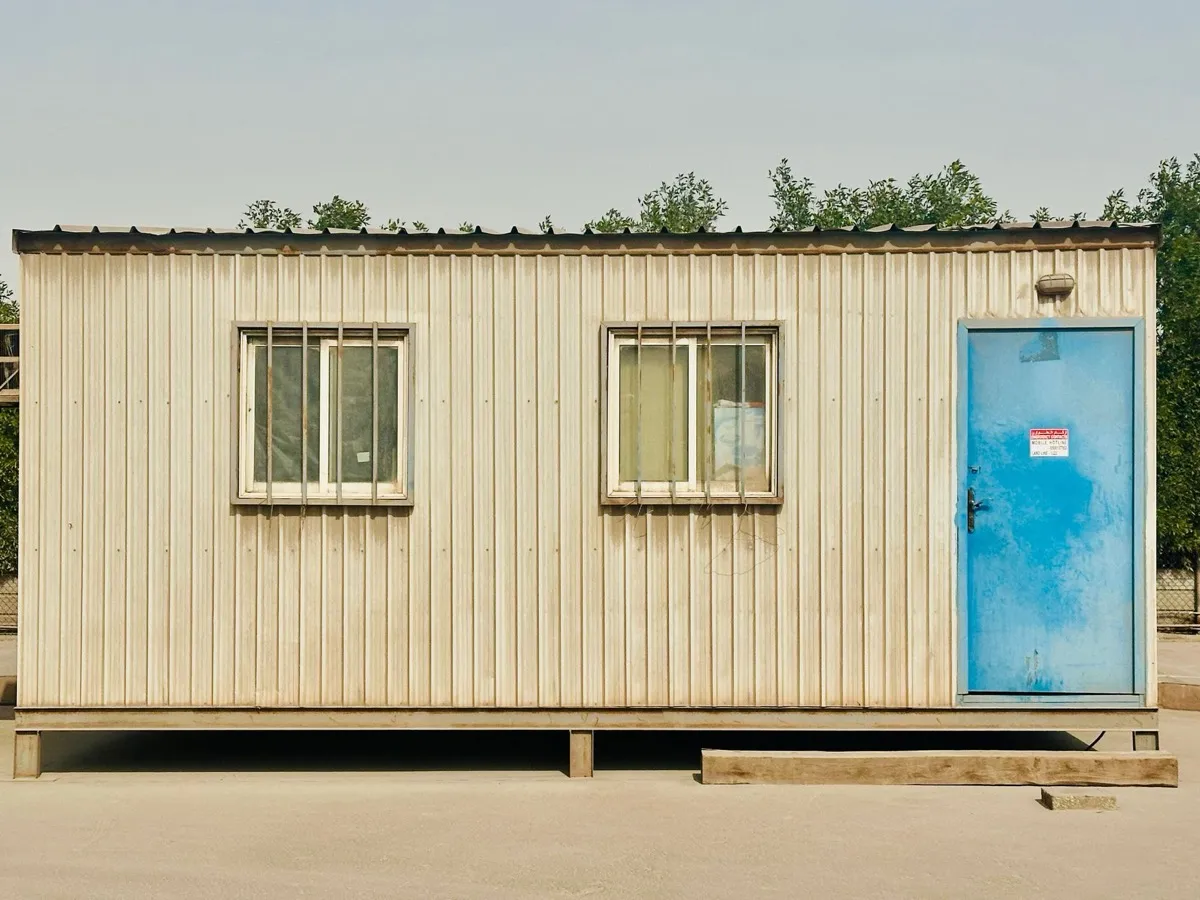 Office container portacamp dengan dua jendela dan pintu baja di lapangan